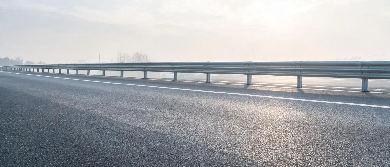 一条空旷道路被前方护栏截断的照片