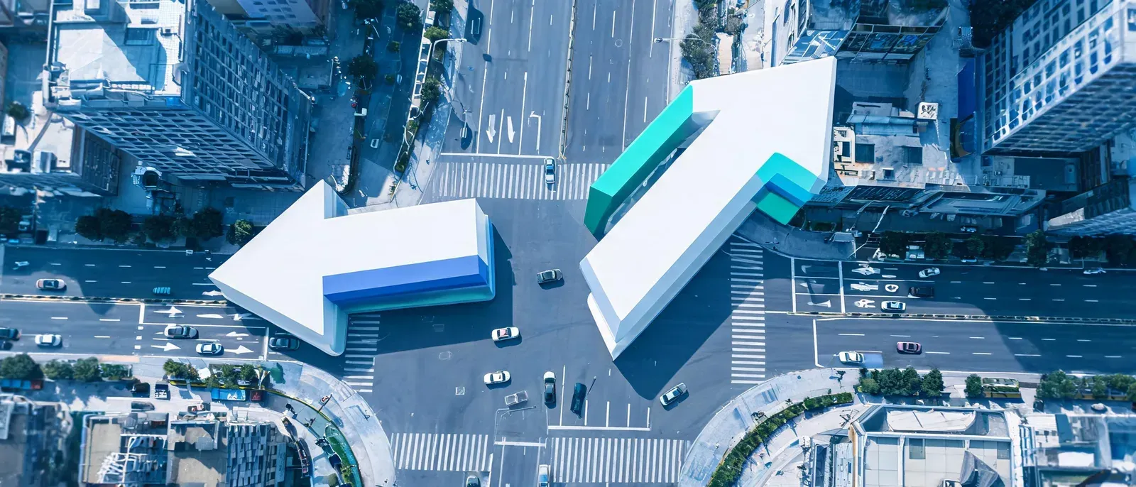 城市十字路口俯拍，上方懸浮著兩個指向不同方向的立體箭頭